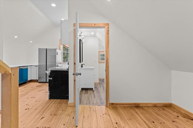 additional living space featuring lofted ceiling, baseboards, and light wood-type flooring