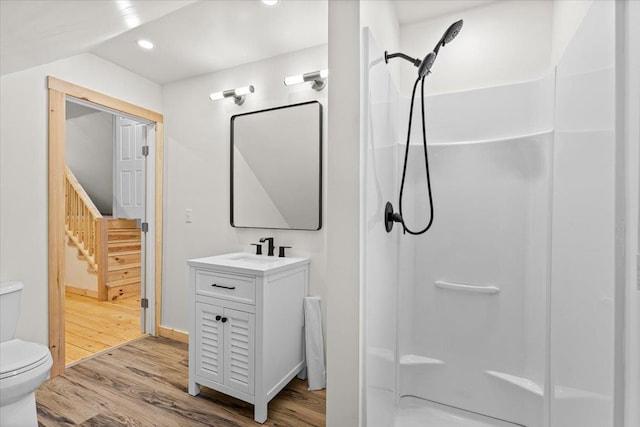 bathroom with toilet, recessed lighting, a stall shower, wood finished floors, and vanity