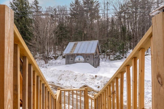 snowy yard featuring an outbuilding and a shed