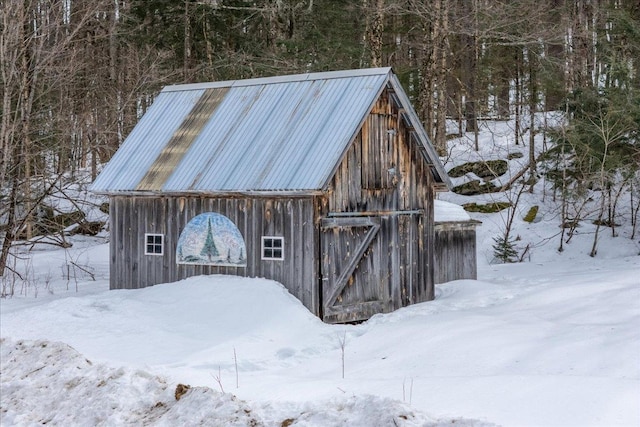 snow covered structure featuring an outdoor structure and a barn