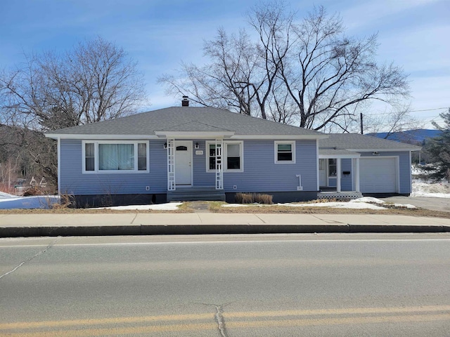 view of front of home featuring an attached garage and a shingled roof