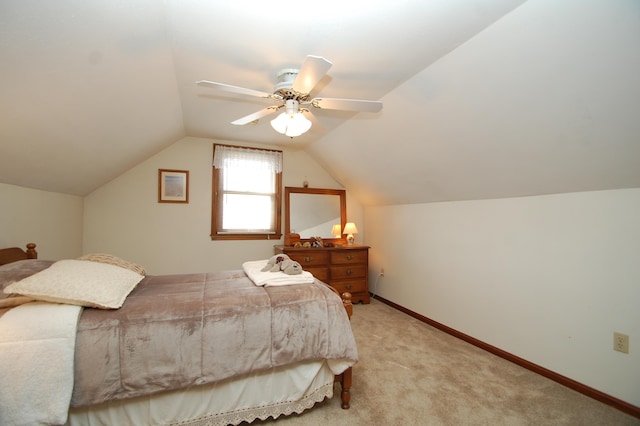 bedroom with light carpet, ceiling fan, baseboards, and vaulted ceiling