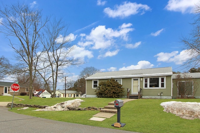 view of front of home with entry steps and a front lawn