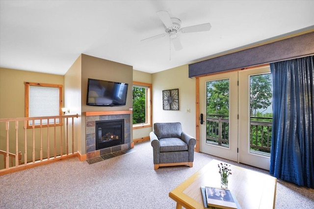 living room with carpet floors, ceiling fan, and a fireplace