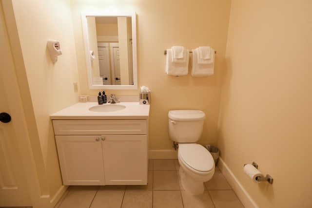 bathroom featuring tile patterned floors, baseboards, toilet, and vanity