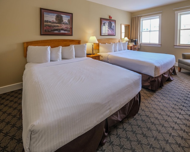 bedroom with dark carpet and baseboards