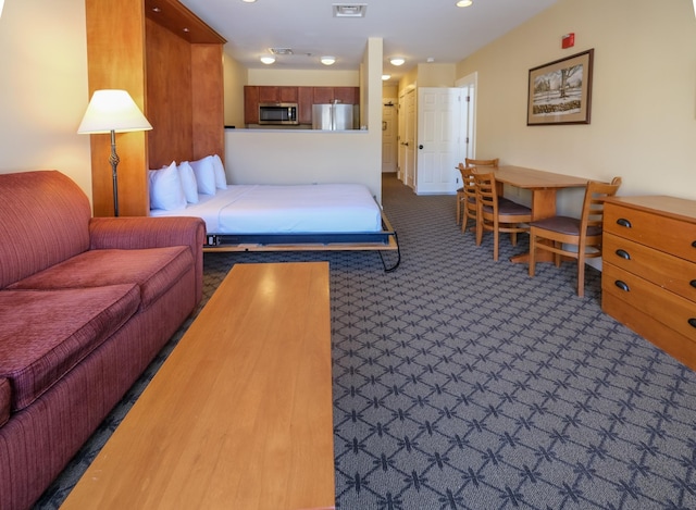 carpeted bedroom featuring visible vents and freestanding refrigerator