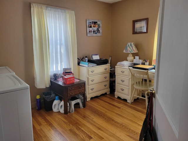 office area with separate washer and dryer and light wood-style flooring