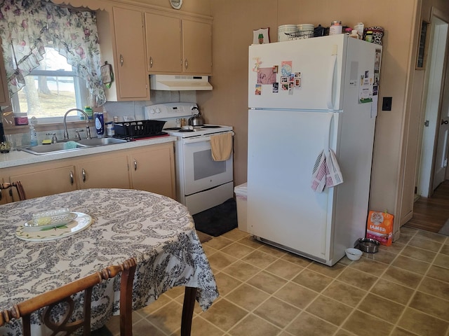 kitchen featuring under cabinet range hood, white appliances, light countertops, and a sink