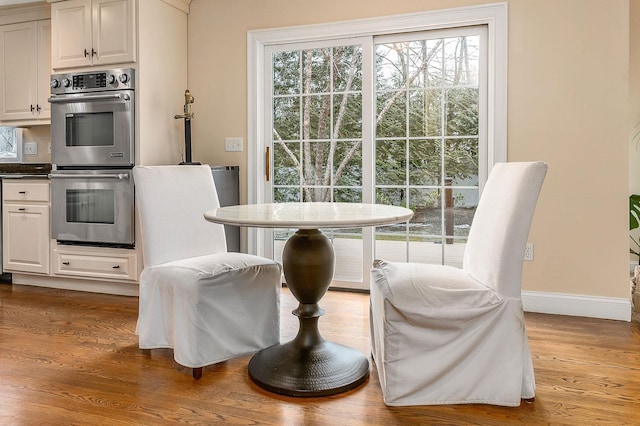 dining space featuring baseboards and wood finished floors