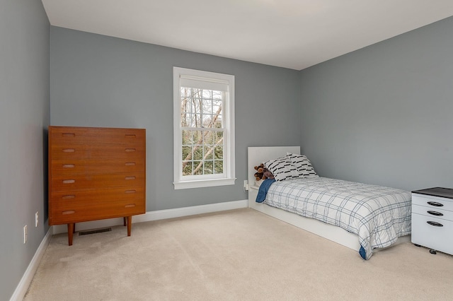 bedroom featuring baseboards and light carpet