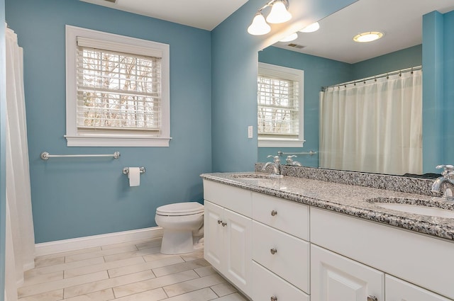 bathroom with a sink, visible vents, baseboards, and toilet