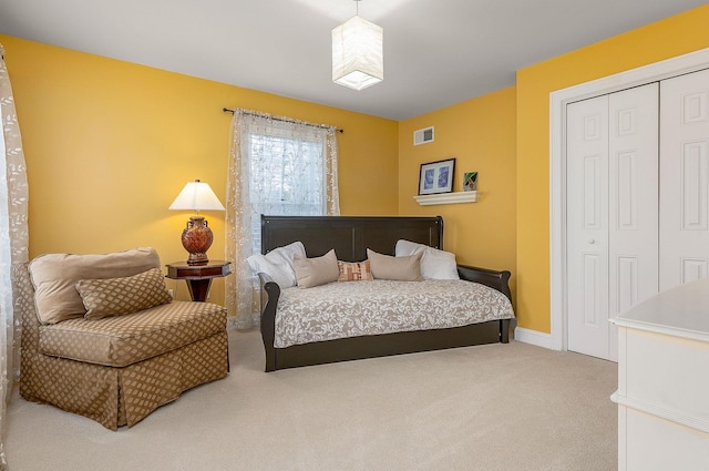 carpeted bedroom with visible vents and a closet