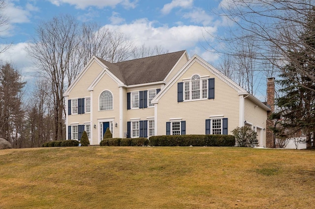 view of front of home with a chimney, a garage, a shingled roof, and a front lawn