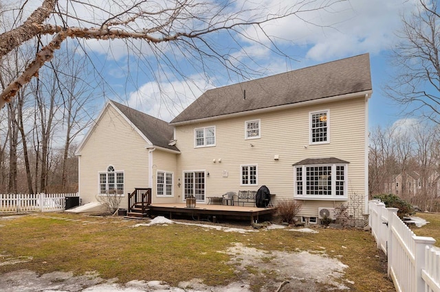 back of house featuring a shingled roof, a fenced backyard, a lawn, and a wooden deck