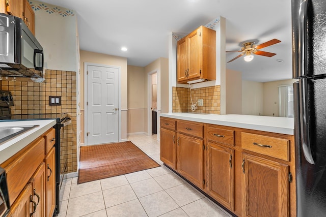 kitchen with tile walls, light countertops, light tile patterned floors, black appliances, and a ceiling fan