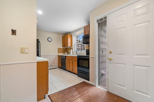 kitchen with light countertops, light tile patterned floors, brown cabinetry, black appliances, and a sink