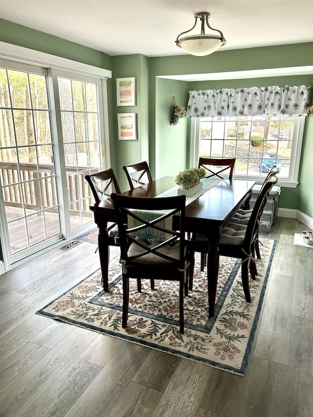 dining room featuring hardwood / wood-style floors, plenty of natural light, baseboards, and visible vents