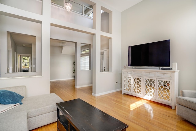 living room featuring plenty of natural light, wood finished floors, and baseboards