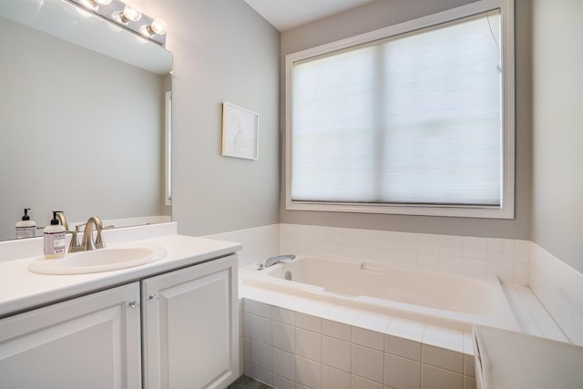 bathroom featuring vanity, a garden tub, and plenty of natural light