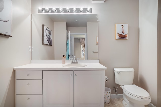 bathroom with baseboards, toilet, and vanity