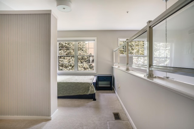 corridor with carpet flooring, baseboards, and visible vents