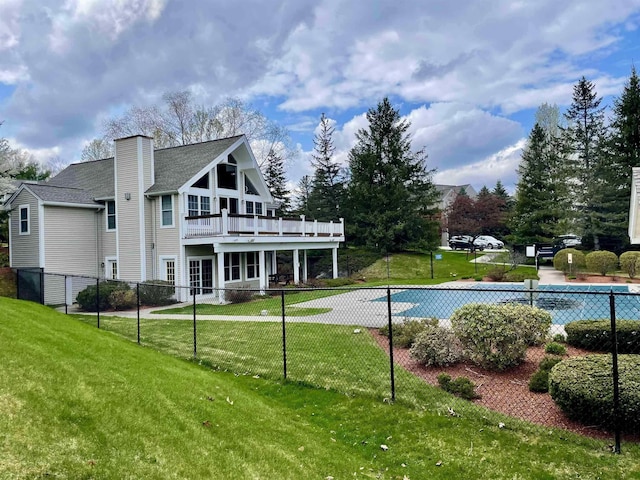 back of property featuring a wooden deck, a lawn, a chimney, and fence