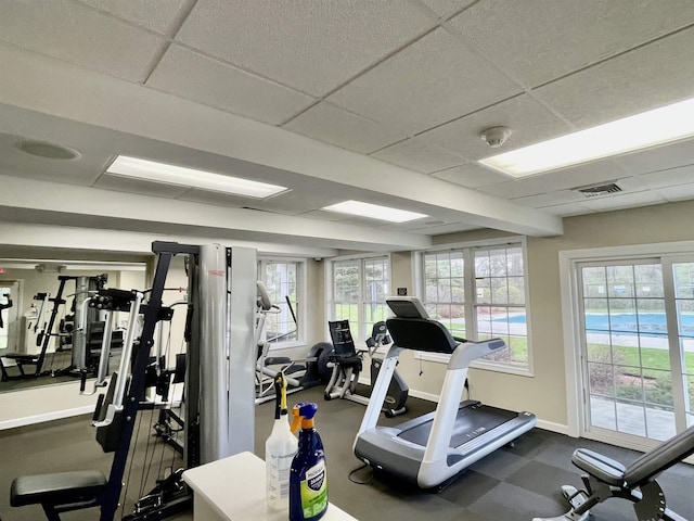 gym featuring baseboards, visible vents, and a drop ceiling