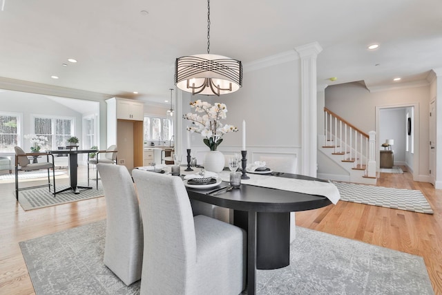 dining area with light wood-type flooring, stairway, a healthy amount of sunlight, and ornamental molding