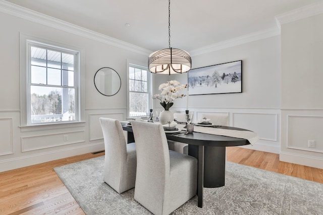 dining space featuring a chandelier, crown molding, and wood finished floors