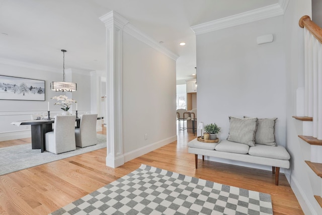 living area featuring a notable chandelier, recessed lighting, crown molding, light wood finished floors, and baseboards