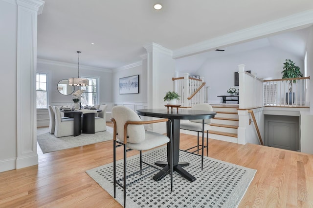 dining space with crown molding, wainscoting, light wood-style flooring, recessed lighting, and a notable chandelier