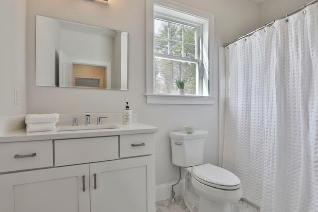 full bathroom with baseboards, toilet, and vanity