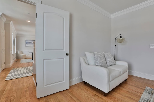 sitting room with crown molding, light wood-style flooring, and baseboards