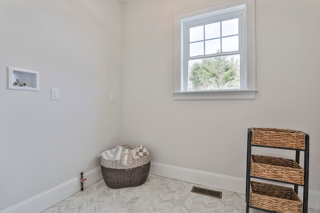 clothes washing area with visible vents, baseboards, washer hookup, and laundry area