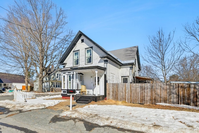 victorian home with fence and covered porch