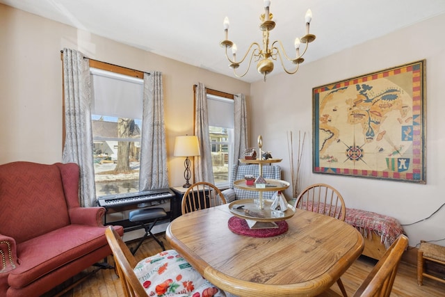 dining area featuring a notable chandelier, a healthy amount of sunlight, and wood finished floors