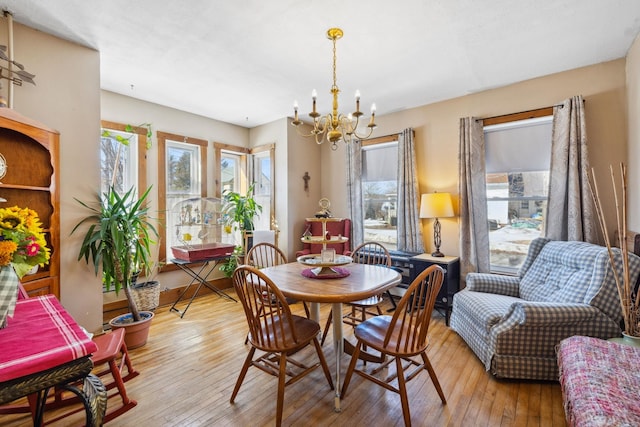 dining room with an inviting chandelier, hardwood / wood-style flooring, and plenty of natural light