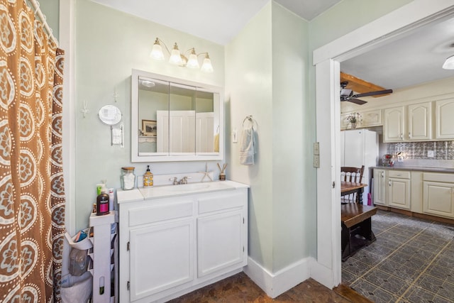 bathroom featuring baseboards, vanity, backsplash, and a ceiling fan