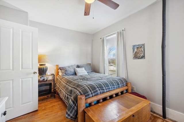 bedroom featuring light wood finished floors, baseboards, and a ceiling fan