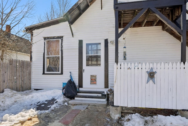 snow covered property entrance featuring fence