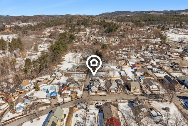 snowy aerial view featuring a mountain view and a residential view