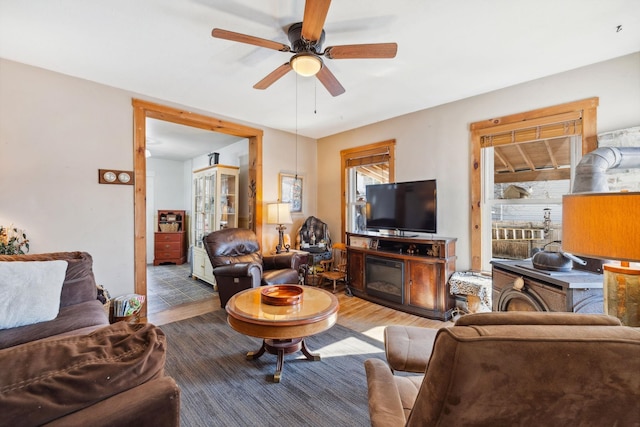 living area with a ceiling fan and wood finished floors