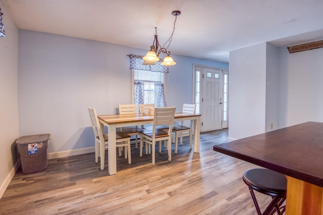 dining area featuring light wood-type flooring and baseboards