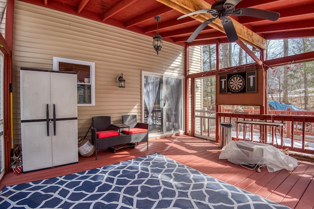 sunroom with lofted ceiling with beams and a ceiling fan