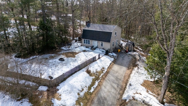 snowy aerial view with a wooded view