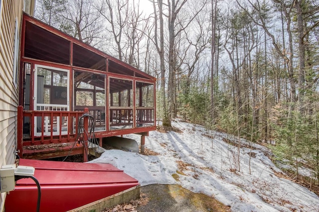 snow covered deck featuring a sunroom