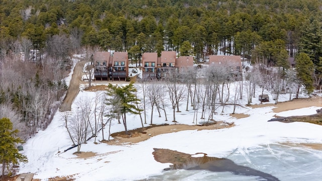 snowy aerial view featuring a forest view