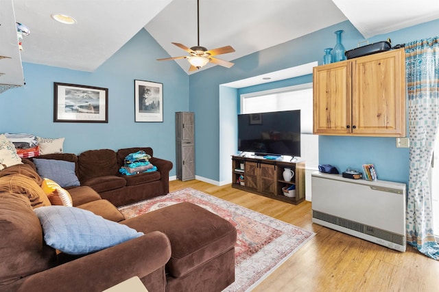 living area with light wood-type flooring, lofted ceiling, baseboards, and a ceiling fan