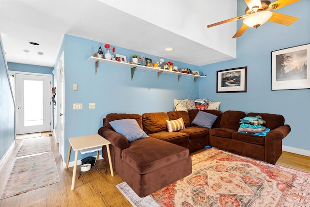 living area featuring light wood-style flooring, baseboards, and ceiling fan